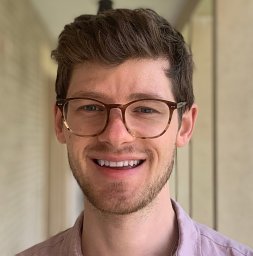Headshot for Fabian Reitzug, smiling, short brown hair, glasses