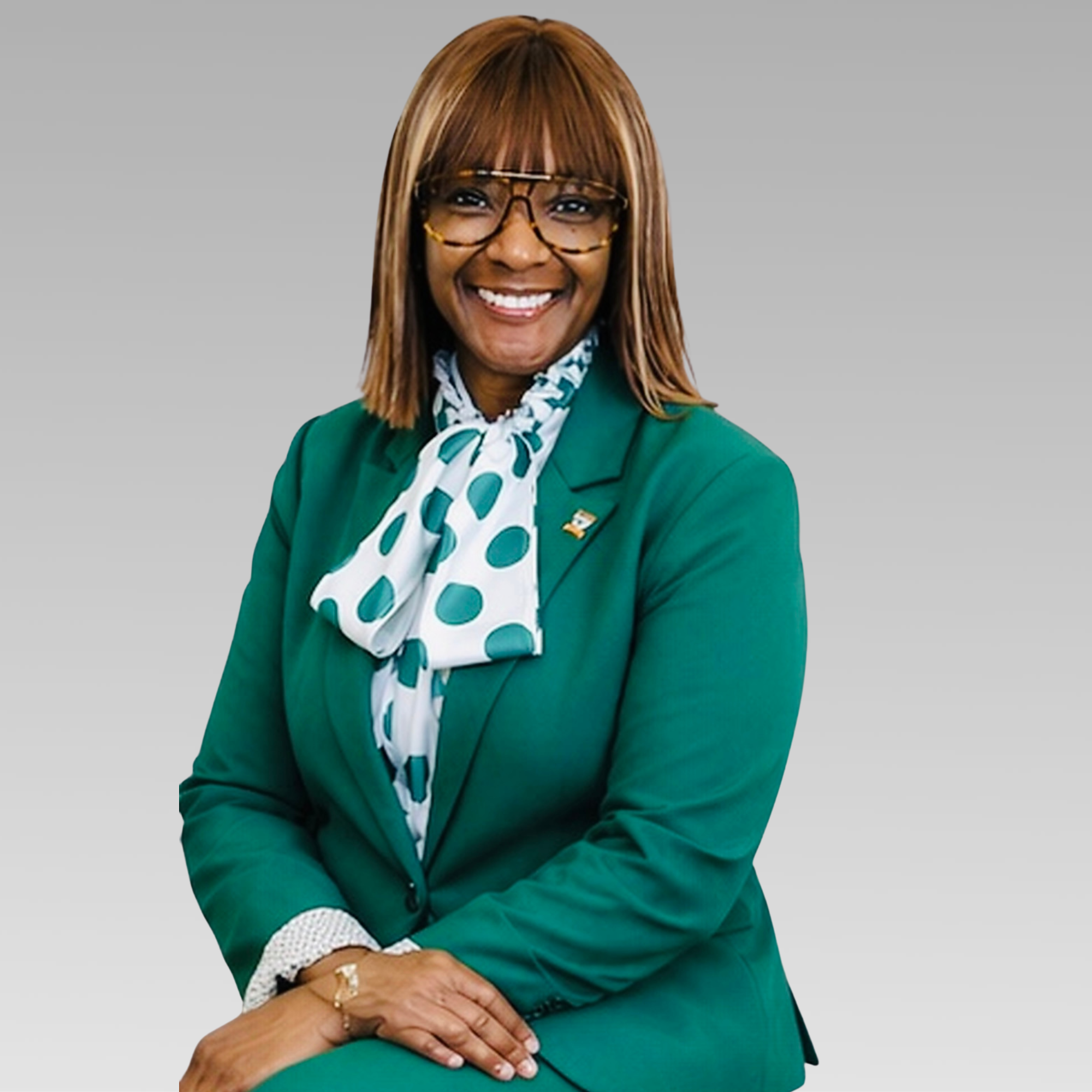 Dr. Dee Jordan, smiling, glasses, green suit