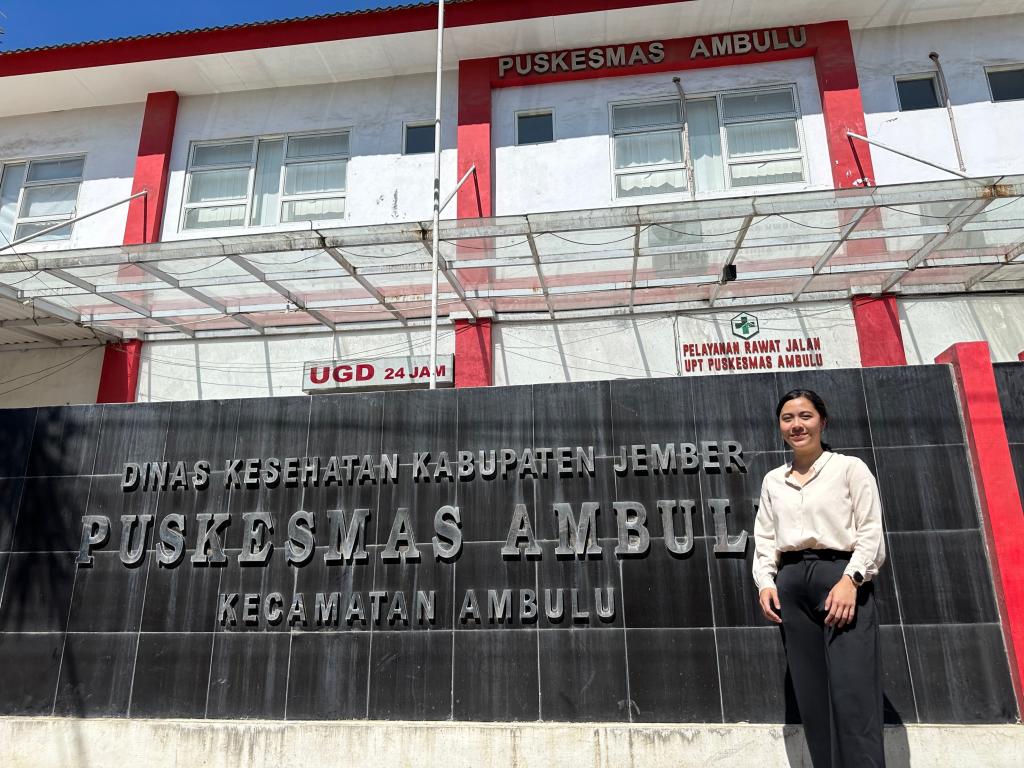 Celline posing in front of her research site, Puskesmas Ambulu, a health facility in Indonesia. 