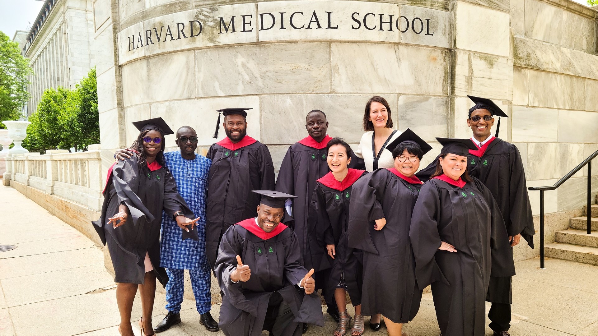 MMSc-GHD Class of 2020 in crimson and black regalia outside of Harvard Medical School marble wall