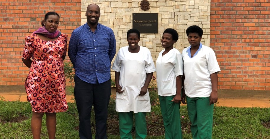 Dr. Ntizimira and 4 caregivers outside of a palliative care center.