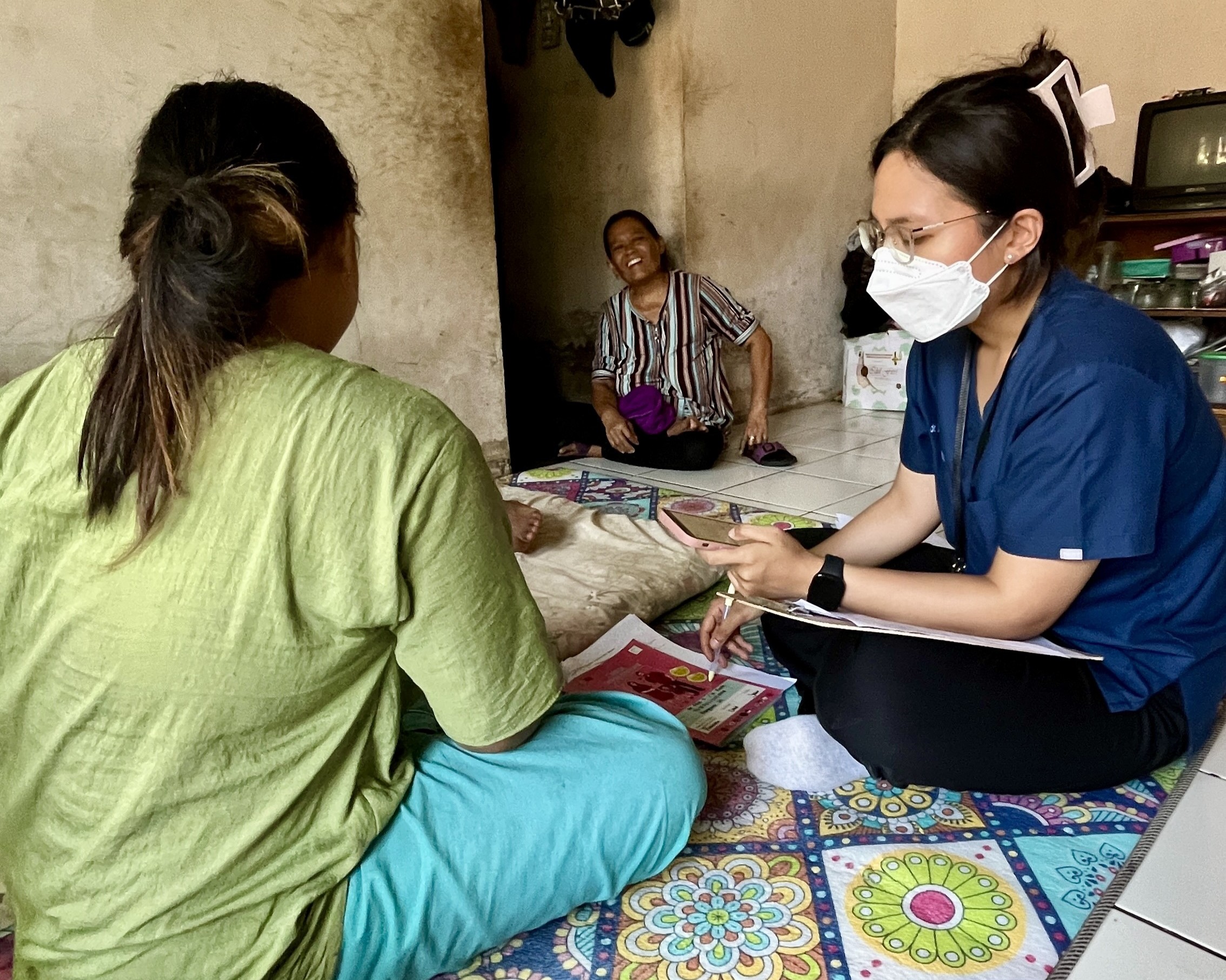 Dwita was doing a home visit. The mother, seen in the background, was smiling while assisting the young mother in the green shirt as she answered questions from the PI. This interaction highlights the enduring role of mothers, who often continue supporting their children, even as they transition into motherhood, guiding them in raising their children.