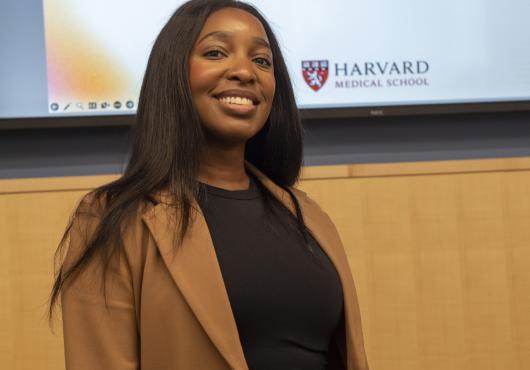 Tsitsi Nyathi stands in front of the cover slide for her capstone presentation