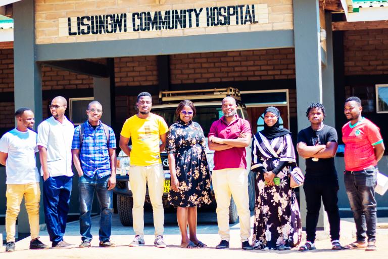 People standing in front of a community hospital in Malawi