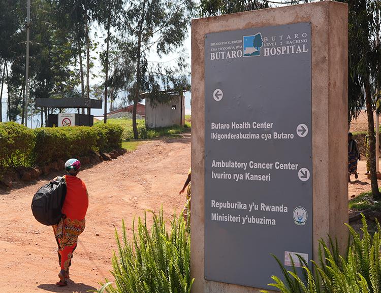 Person walking up a dirt road to Butaro clinic