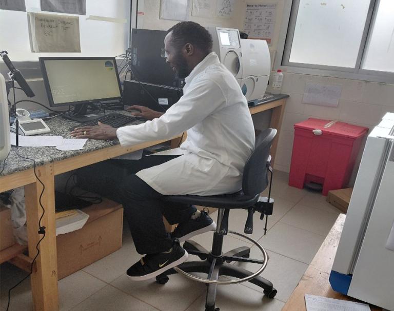 Person in a white coat working in a lab