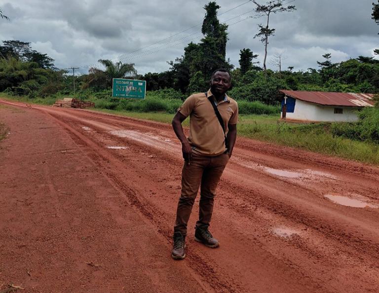 Person standing on a dirt road
