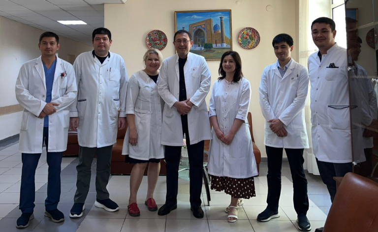 Seven people in white coats standing together