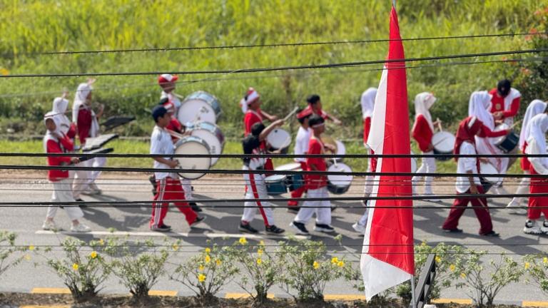 People dressed in white and red march in a parade