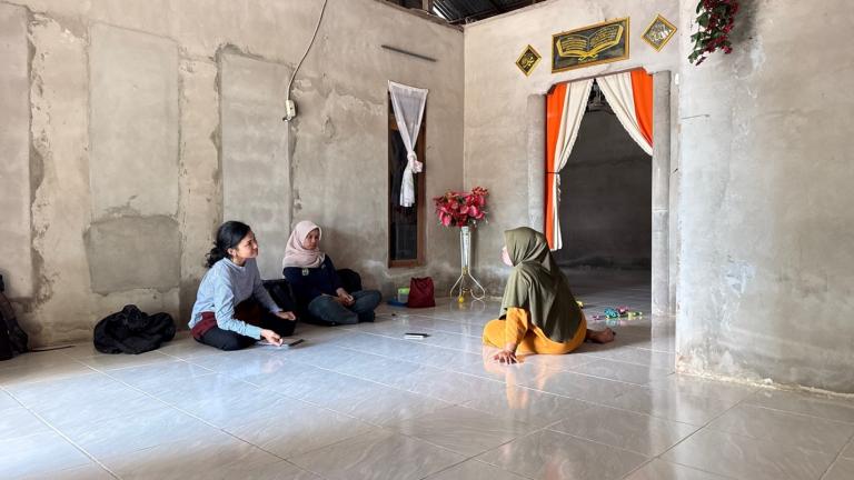 Three women sit in a room taking