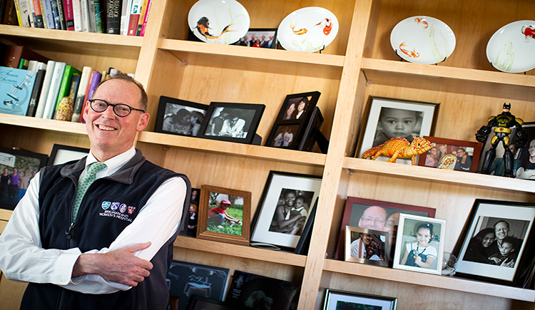 Photo of Paul Farmer standing in front of bookcases in his office